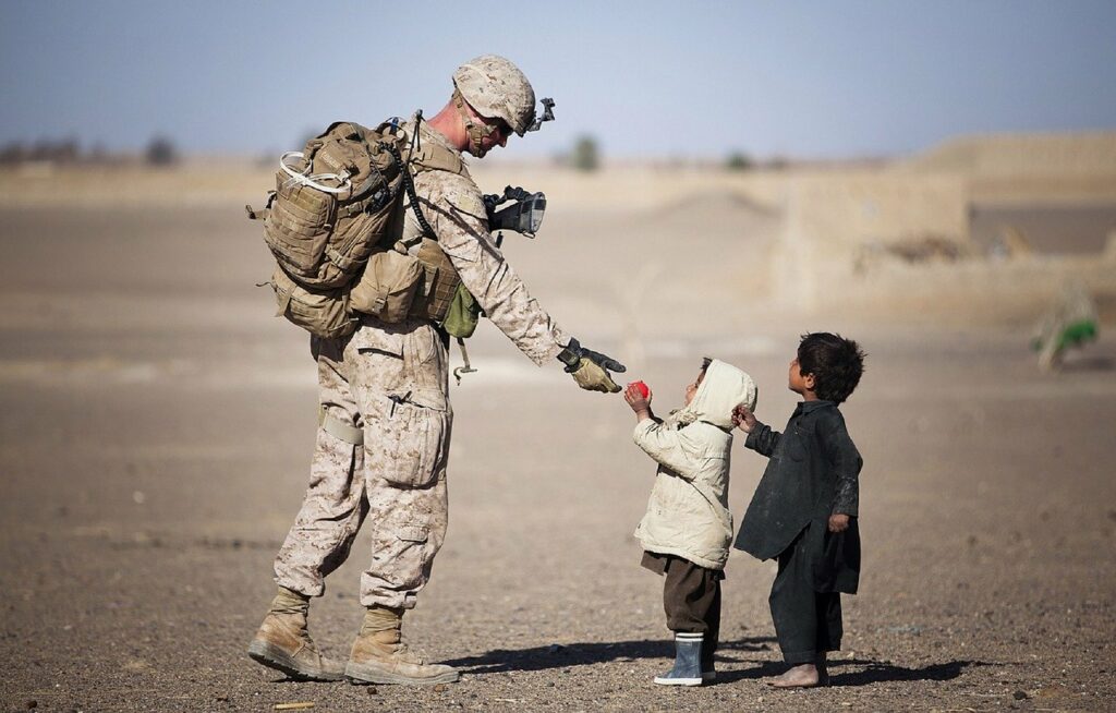 Soldier giving fruit to kids.