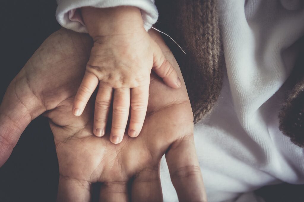 palms of a toddler and an adult 