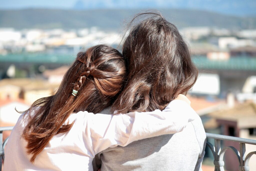 two woman side hugging 