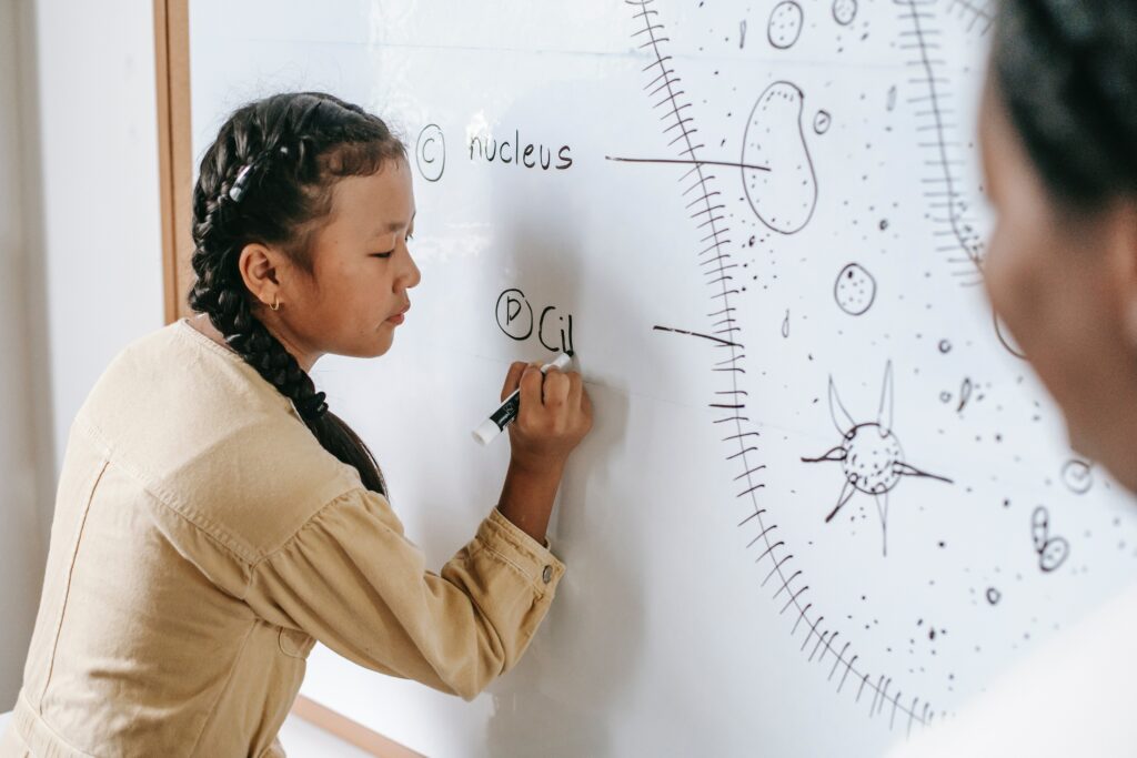 girl writing on white board 